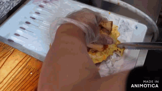 a person is cutting a piece of food with a knife and the words made in animotica are on the bottom of the image