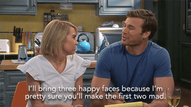 a man and a woman are sitting in a kitchen and the woman is saying " i 'll bring three happy faces