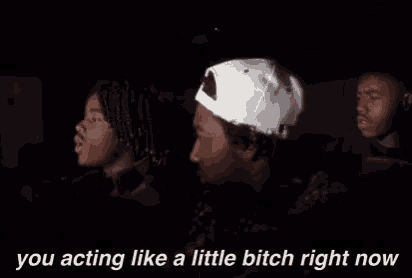 a group of young men are sitting in a car and one of them is wearing a baseball cap .