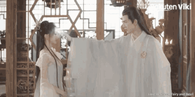 a man and a woman are standing next to each other in a room with the words love between fairy and devil below them