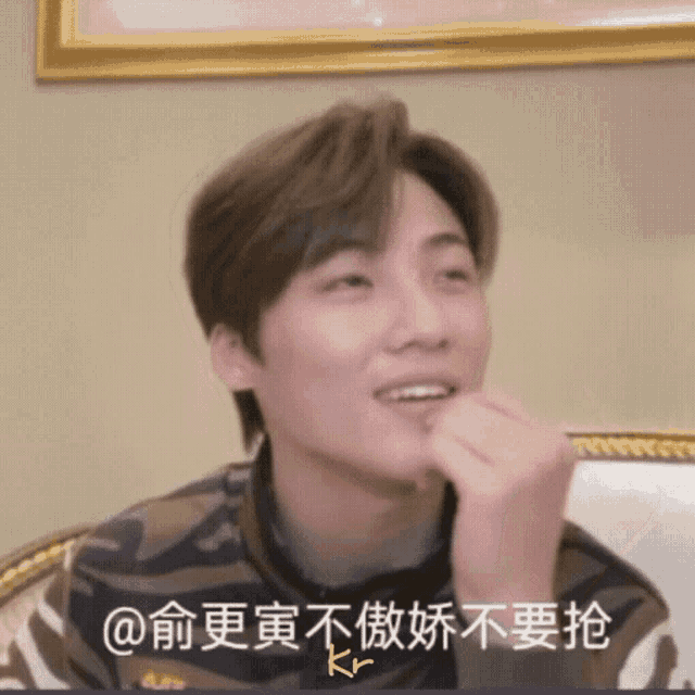 a man sitting on a couch with chinese writing on the bottom right
