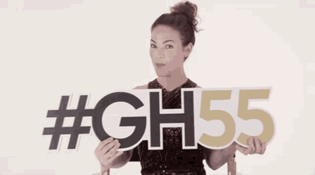 a woman in a red dress is holding a sign that says gh55