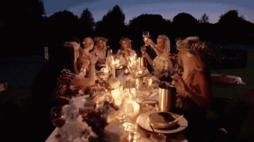 a group of women are sitting at a table with candles on it