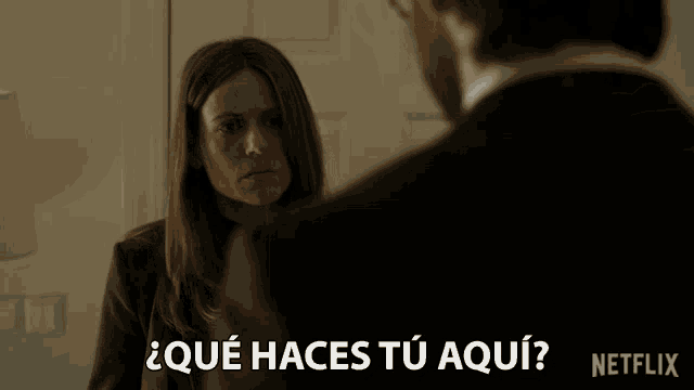 a man and a woman are looking at each other with the words que haces tu aqui in the corner