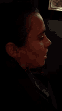 a close up of a person 's face with a picture in the background