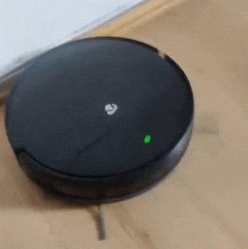 a black robotic vacuum cleaner is sitting on a wooden floor