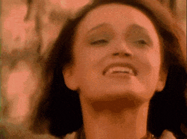a close up of a woman smiling with her eyes closed