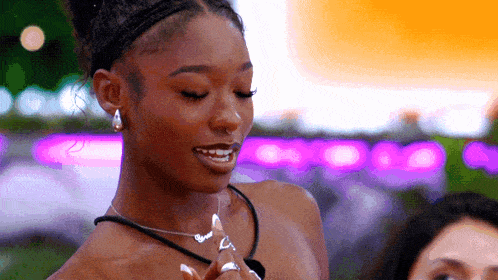 a woman with a nose ring is smiling and wearing a necklace .