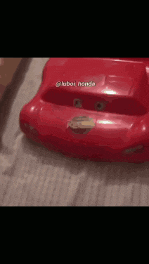 a red lightning mcqueen toy car is laying on a bed