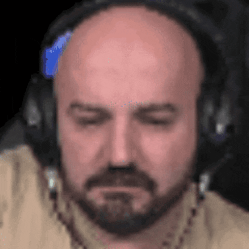 a bald man with a beard is wearing headphones