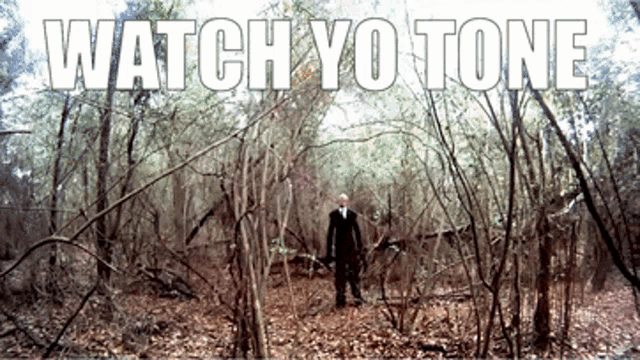 a man in a suit stands in the middle of a forest with the words watch yo tone below him