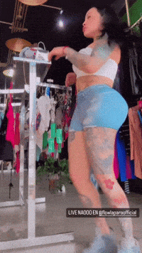 a woman is dancing in front of a sign that says live nadoo en