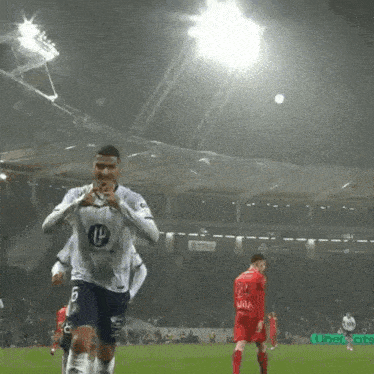 a soccer player wearing a number 14 jersey runs on the field