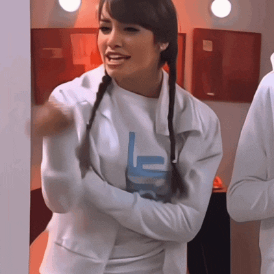 a woman wearing a white jacket with a blue letter l on it
