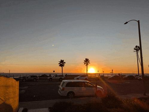a white van is parked in front of a sunset