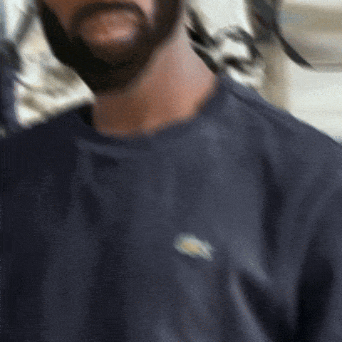 a man with a beard is wearing a blue shirt with a duck on it