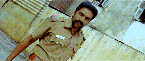 a man in a police uniform is standing in front of a wall with the word root on the bottom