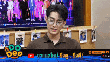 a man wearing glasses is sitting in front of a television with a youtube logo on the screen