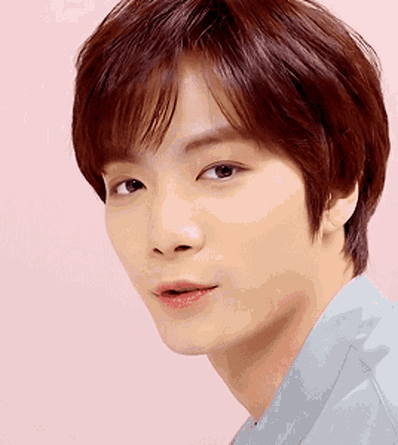 a close up of a man 's face with a pink background