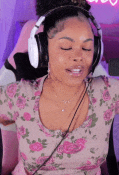 a woman wearing headphones and a pink floral top
