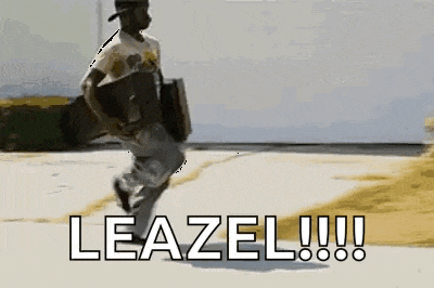 a man is running down a street carrying a box and the word leazel is written on the ground behind him .