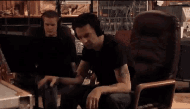 a man in a black shirt is sitting in a chair