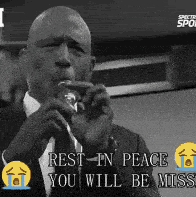 a man in a suit and tie is crying while holding a microphone and saying rest in peace you will be missed .