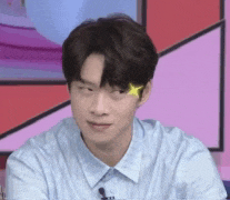 a young man in a blue shirt with a yellow star on his forehead .