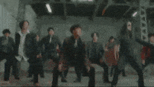 three men in suits and ties are dancing in a room .