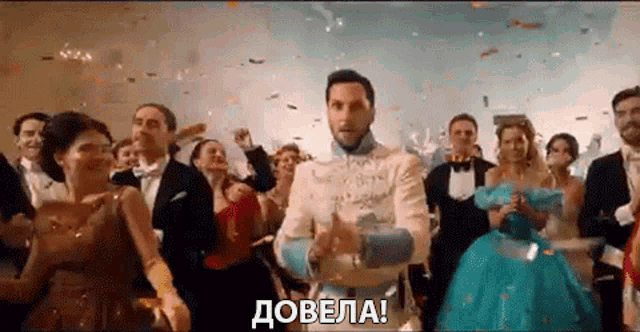 a man in a tuxedo and a woman in a blue dress are dancing at a party .