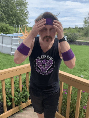 a man wearing a globe gym tank top holds his head