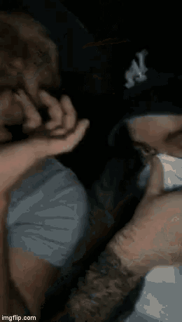 a man is smoking a cigar with a lighter in his hand in the dark .