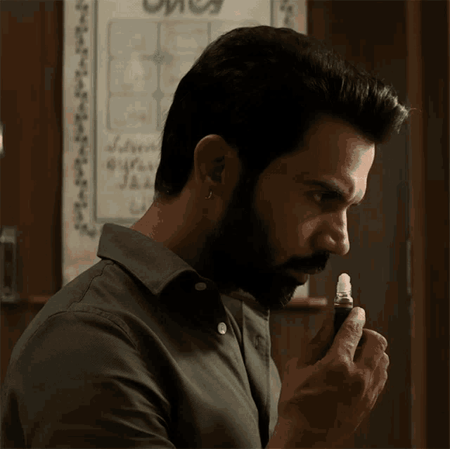 a man with a beard is holding a lighter in his right hand