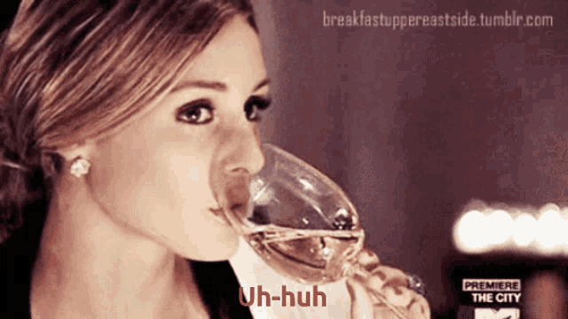 a woman drinking a glass of wine with the words uh-huh on the bottom right
