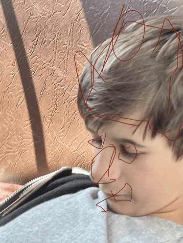 a close up of a boy 's face with a drawing of a face drawn on it