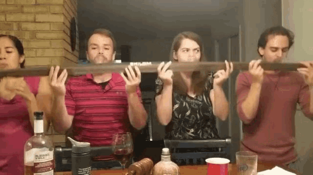 a group of people playing a musical instrument with a bottle of bulleit whiskey in the background