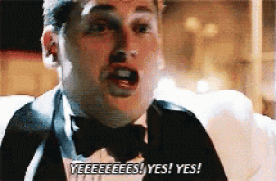 a man in a tuxedo and bow tie is saying yes ! yes !
