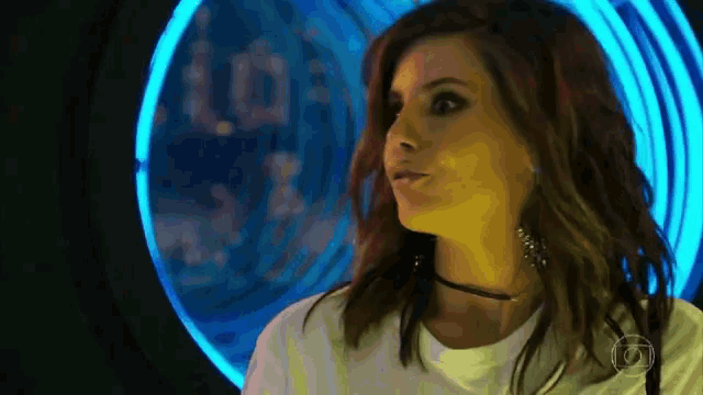 a woman is standing in front of a washing machine with a blue light behind her .