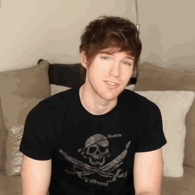 a man wearing a black t-shirt with a skull and crossbones on it