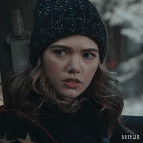 a woman wearing a black hat and a black coat says no