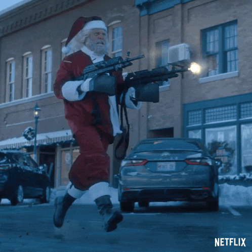 a man dressed as santa claus is holding a gun in front of a netflix car