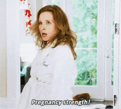 a pregnant woman in a white robe says pregnancy strength