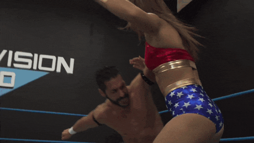 a woman in a wonder woman outfit is wrestling a man