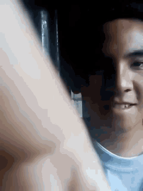 a close up of a young man 's face with a hand behind him