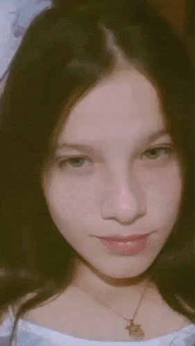 a close up of a young girl 's face with a necklace .