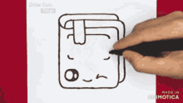 a person is drawing a cartoon book with a face on it
