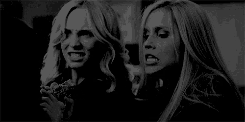 a couple of women are standing next to each other in a black and white photo .
