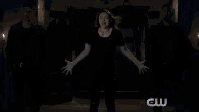 a blurry picture of a woman in a blue shirt with her arms outstretched