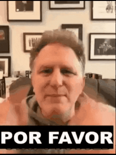 a man is sitting in front of a wall with pictures and a sign that says `` por favor '' .