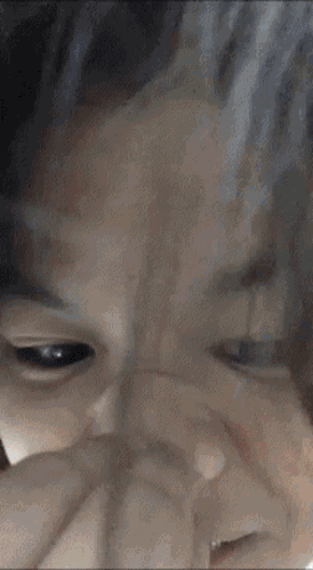 a close up of a girl covering her mouth with her hand